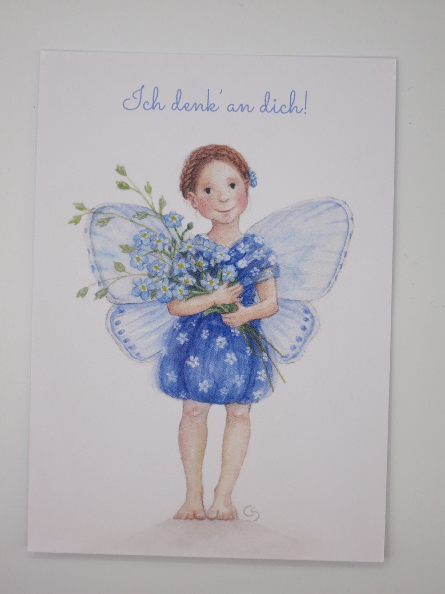 Postkarte mit Elfe in blauen Schmetterlingsflügeln, die einen Strauß Vergissmeinnicht hält – Ich denk' an dich PKGR2