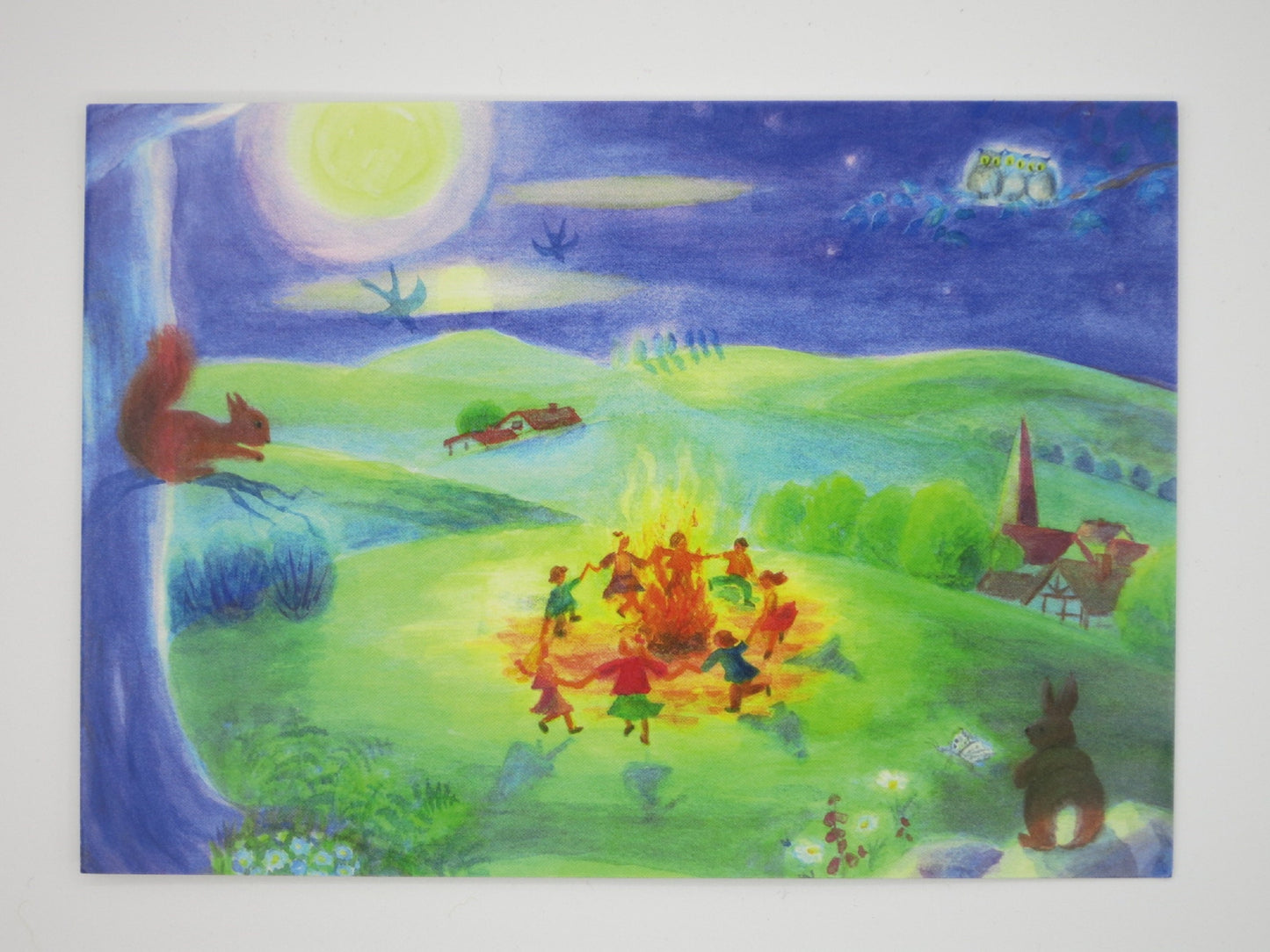 Postkarte Tanz um das Johannifeuer von Dorothea Schmidt: Kinder tanzen aus der Vogelperspektive um das Sonnwendfeuer