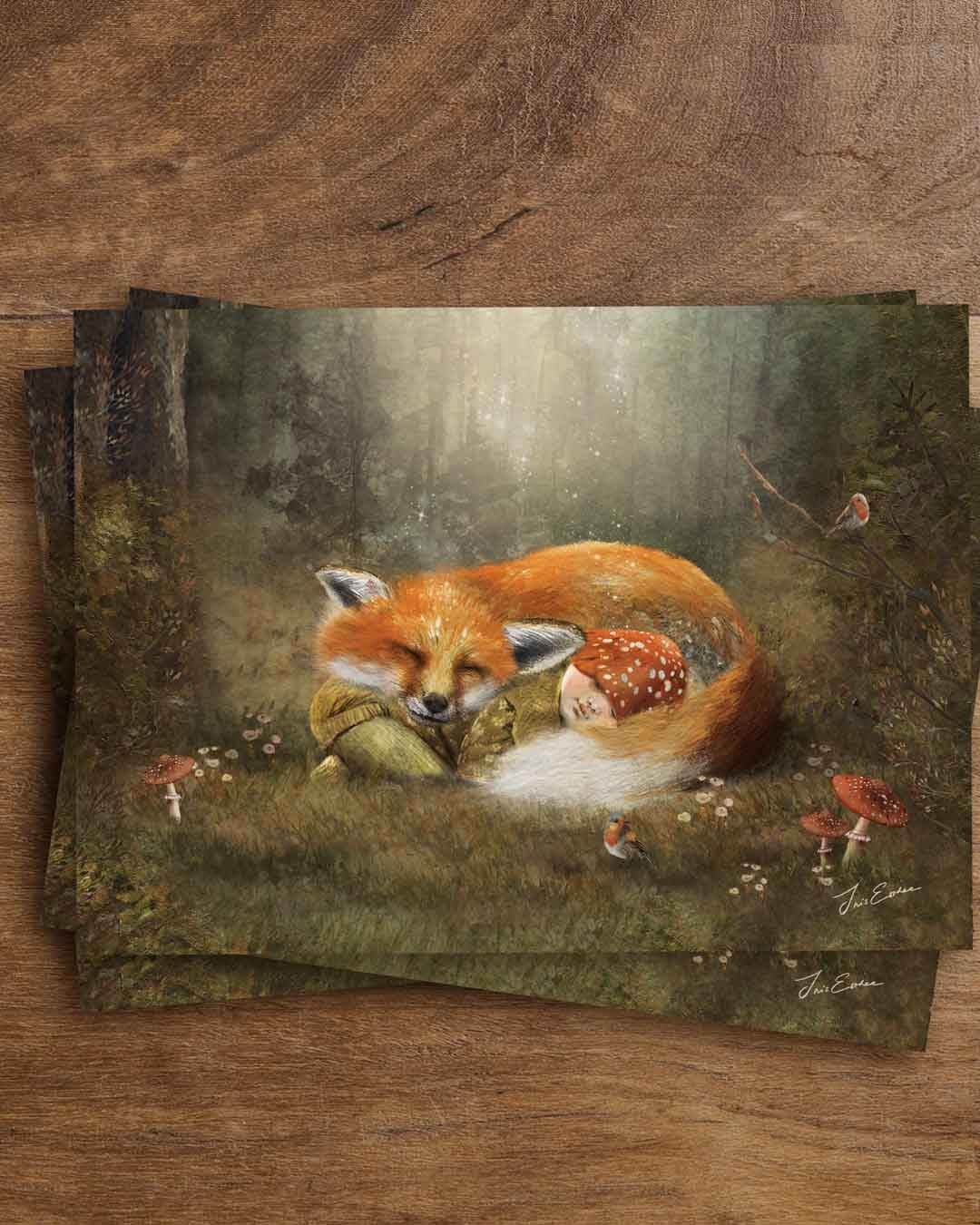 Postkarte „Wald Wiegenlied“ von Iris Esther im Querformat: ein zusammengerollter roter Fuchs schläft mit geschlossenen Augen auf einer Waldlichtung, an seine Rute geschmiegt schläft ein Kind mit rot-weiß gepunkteter Fliegenpilzmütze, ringsum Fliegenpilze, kleine weiße Blüten und zwei Rotkehlchen