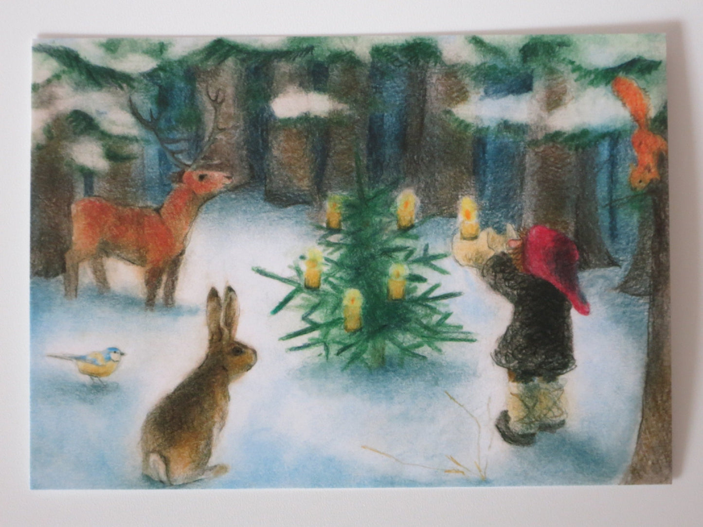 Waldweihnacht-Postkarte für Kinder: Wichtel entzündet Kerzen am Waldbaum, Reh, Hase, Meise und Eichhörnchen schauen zu