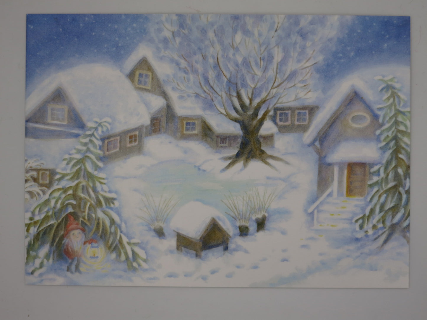 Postkarte Weihnachten auf dem Hof von Eveline Rothenbuehler, Tomte mit Laterne auf verschneitem Bauernhof