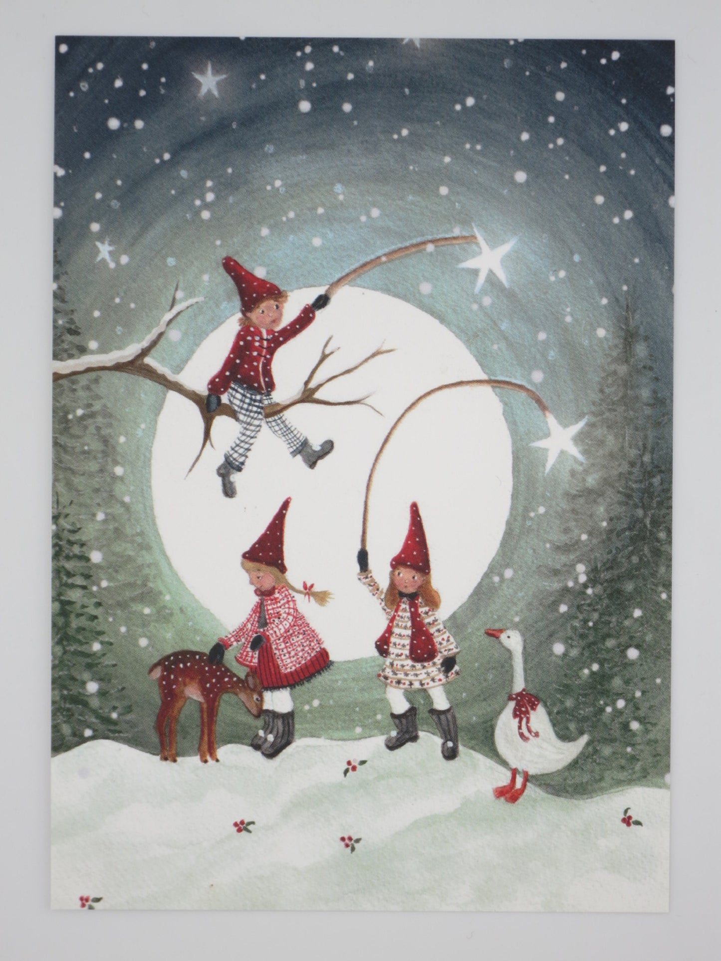 Winterpostkarte für Kinder: Zwergenkinder spielen Seilspringen und klettern vor riesigem Vollmond, Reh und Gans schauen zu