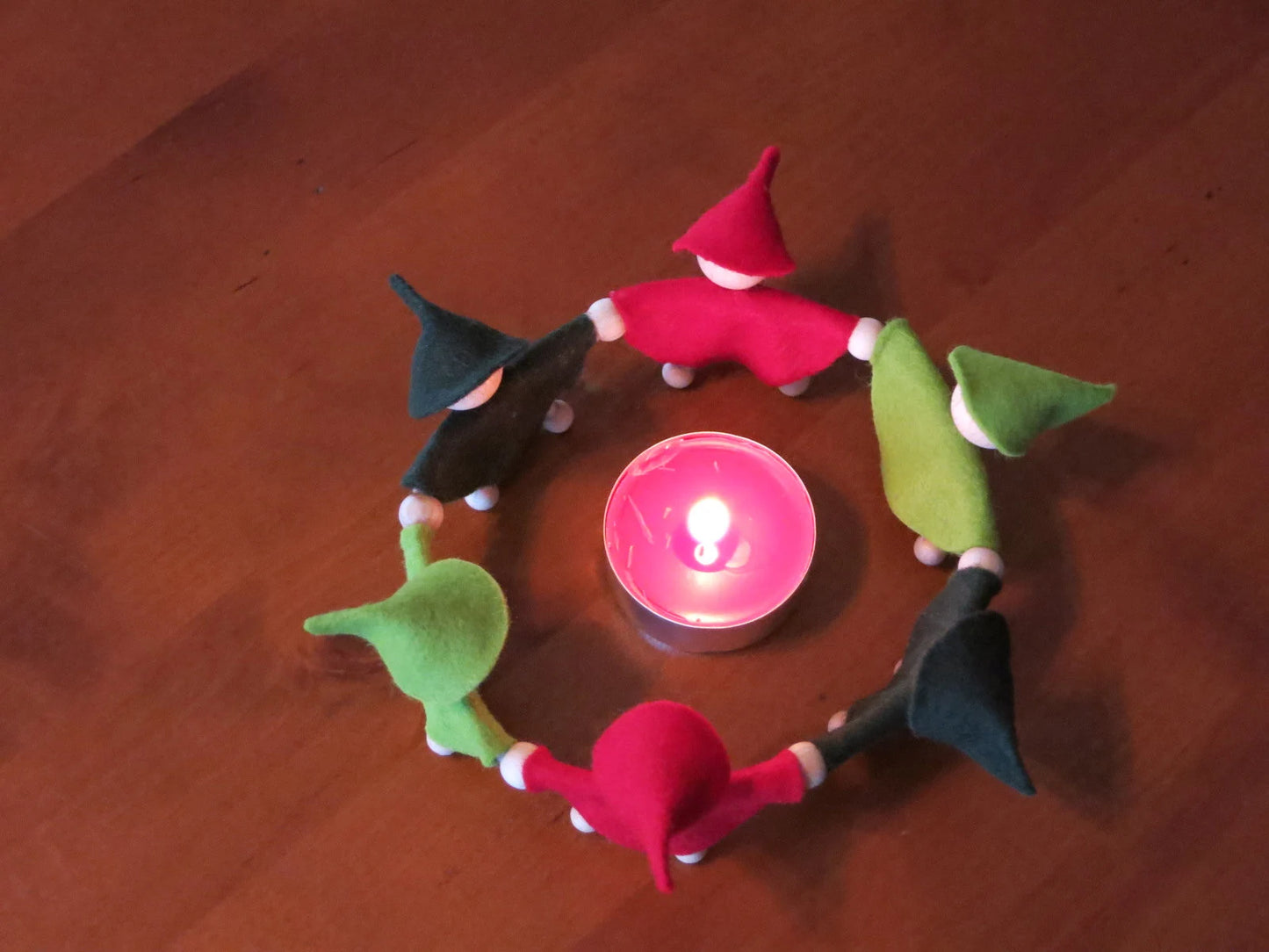 Adventszwergenkreis aus rotem und grünem Filz mit Teelicht, von oben fotografiert für den Waldorf Jahreszeitentisch.