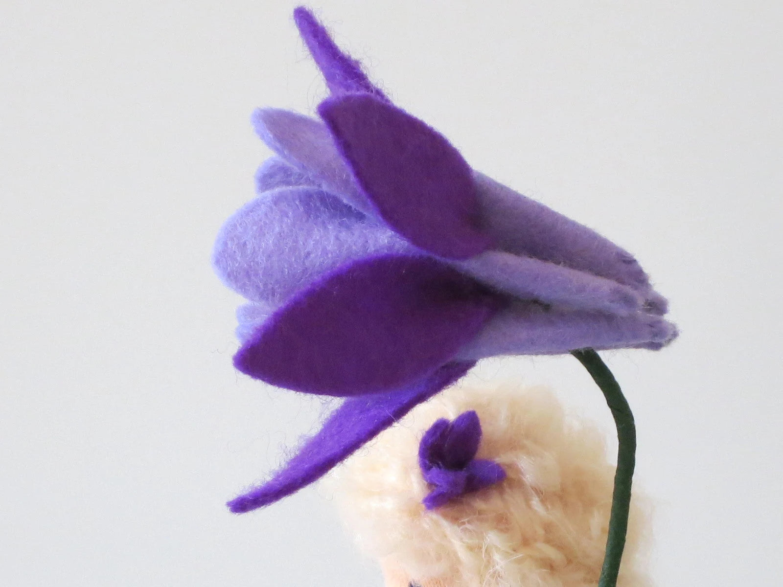 Detailaufnahme der mehrlagigen violetten Akelei-Filzblüte am handgefertigten Blumenkind, Art. FR57.