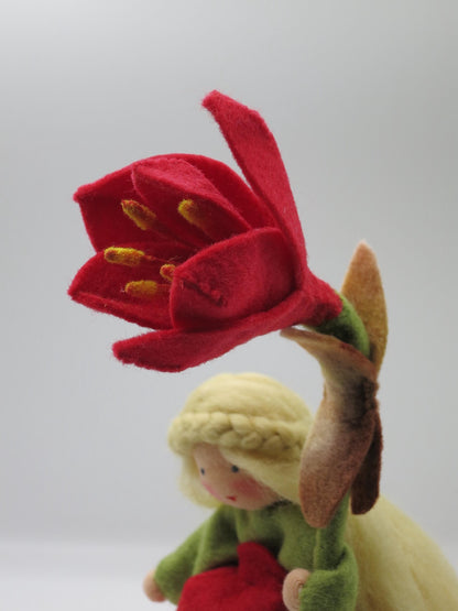 Detailaufnahme der dunkelroten Amaryllis-Filzblüte mit gelben Staubgefäßen am handgefertigten Blumenkind.