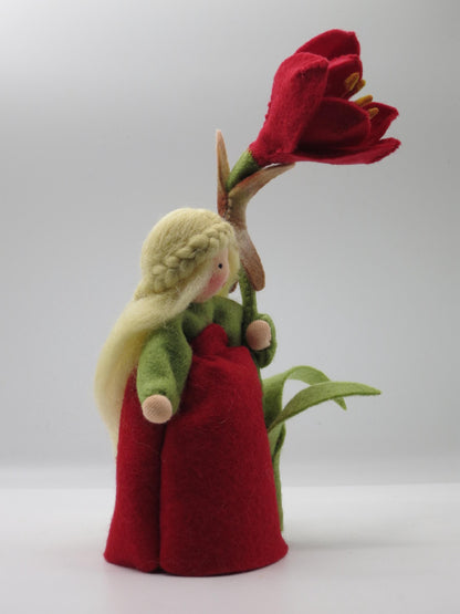 Seitliche Ganzfigur des Amaryllis-Blumenkinds im roten Filzkleid mit grünen Ärmeln und hoher Blüte.