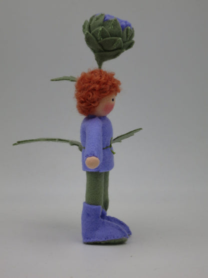 Zweite Seitenansicht des Artischocken-Blumenkinds Art. SO152 mit rotem Wollhaar, grüner Hose und violetten Filzstiefeln.