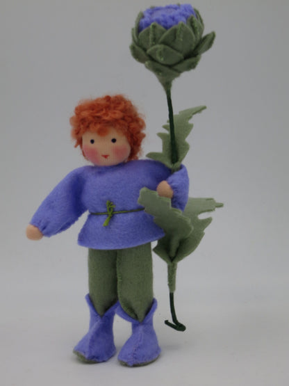 Frontalansicht des Artischocken-Blumenkinds Art. SO152 mit violetter Filzkleidung, rotem Wollhaar und großer Artischockenblüte.