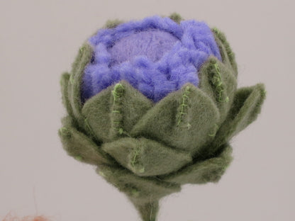 Nahaufnahme der violett-grünen Artischockenblüte aus Wollfilz am handgefertigten Sommer-Blumenkind Art. SO152.