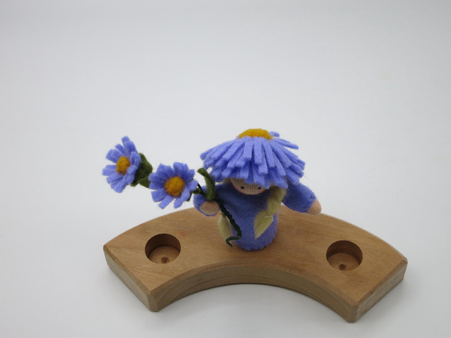 Aster-Blumenkind Art. HE54 mit Asternzweig auf dem gebogenen Holz-Geburtstagsring, aus leicht erhöhter Perspektive.