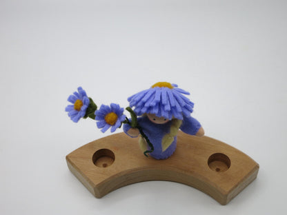 Aster-Blumenkind Art. HE54 mit Asternzweig auf dem gebogenen Holz-Geburtstagsring, aus leicht erhöhter Perspektive.