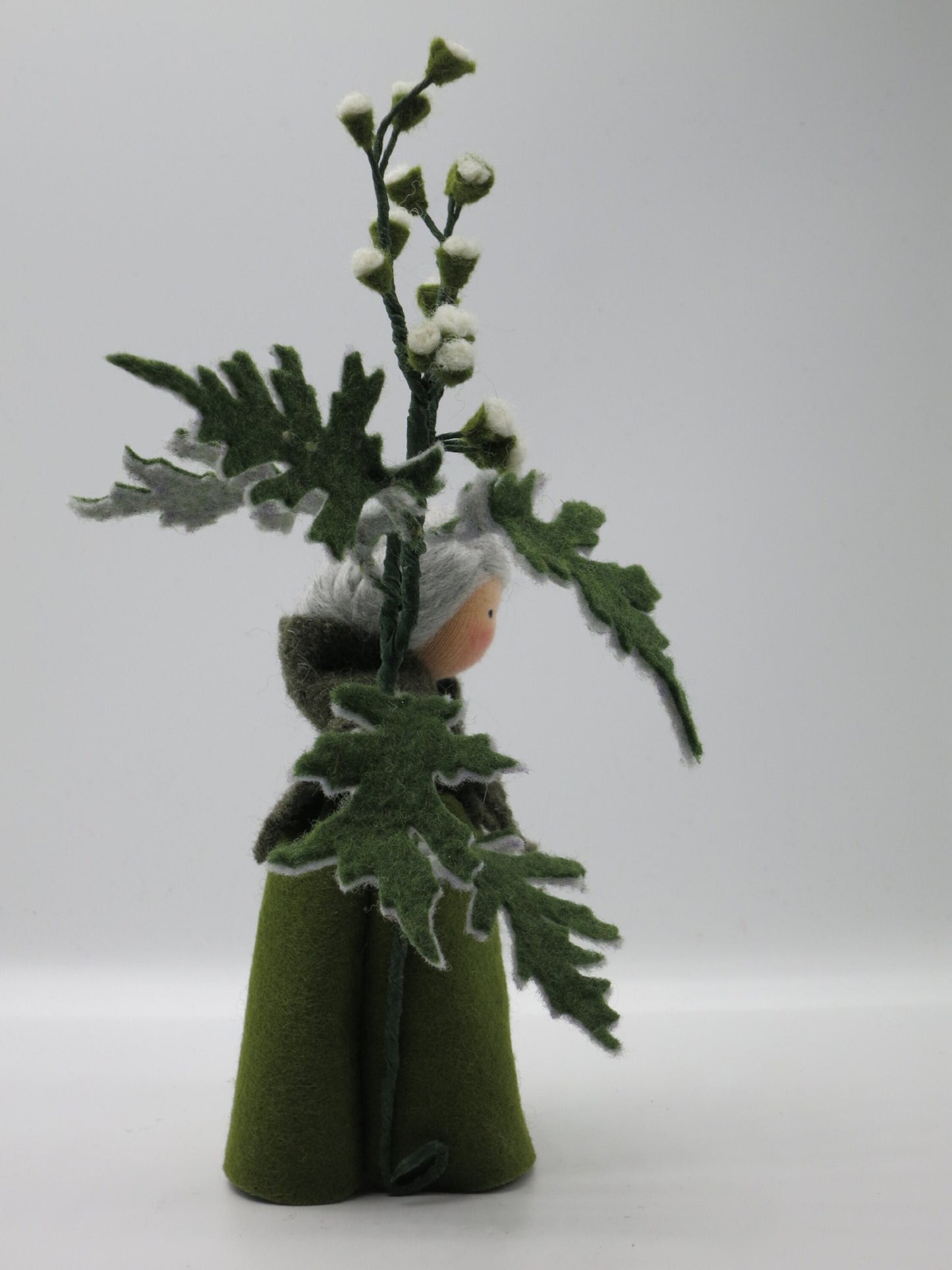 Seitenansicht des Beifuß-Blumenkinds Art. SO16, dessen großer Filz-Beifußzweig mit gezackten Blättern die Figur umrahmt.