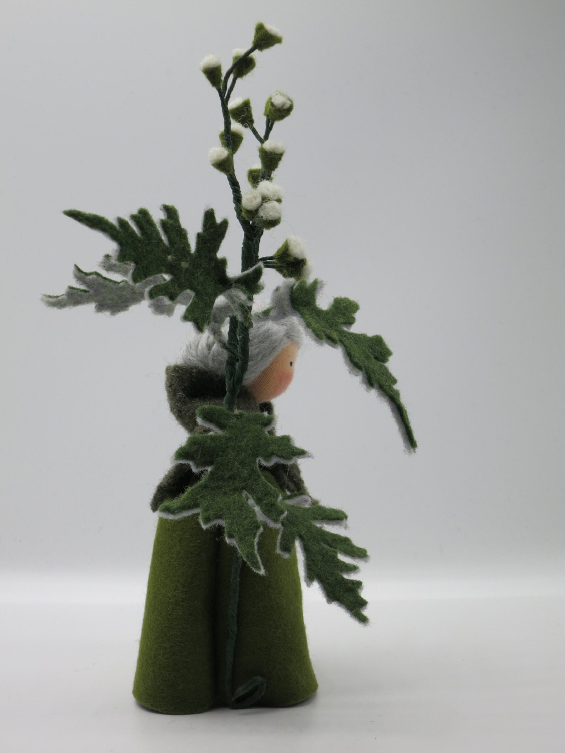 Seitenansicht des Beifuß-Blumenkinds Art. SO16, dessen großer Filz-Beifußzweig mit gezackten Blättern die Figur umrahmt.