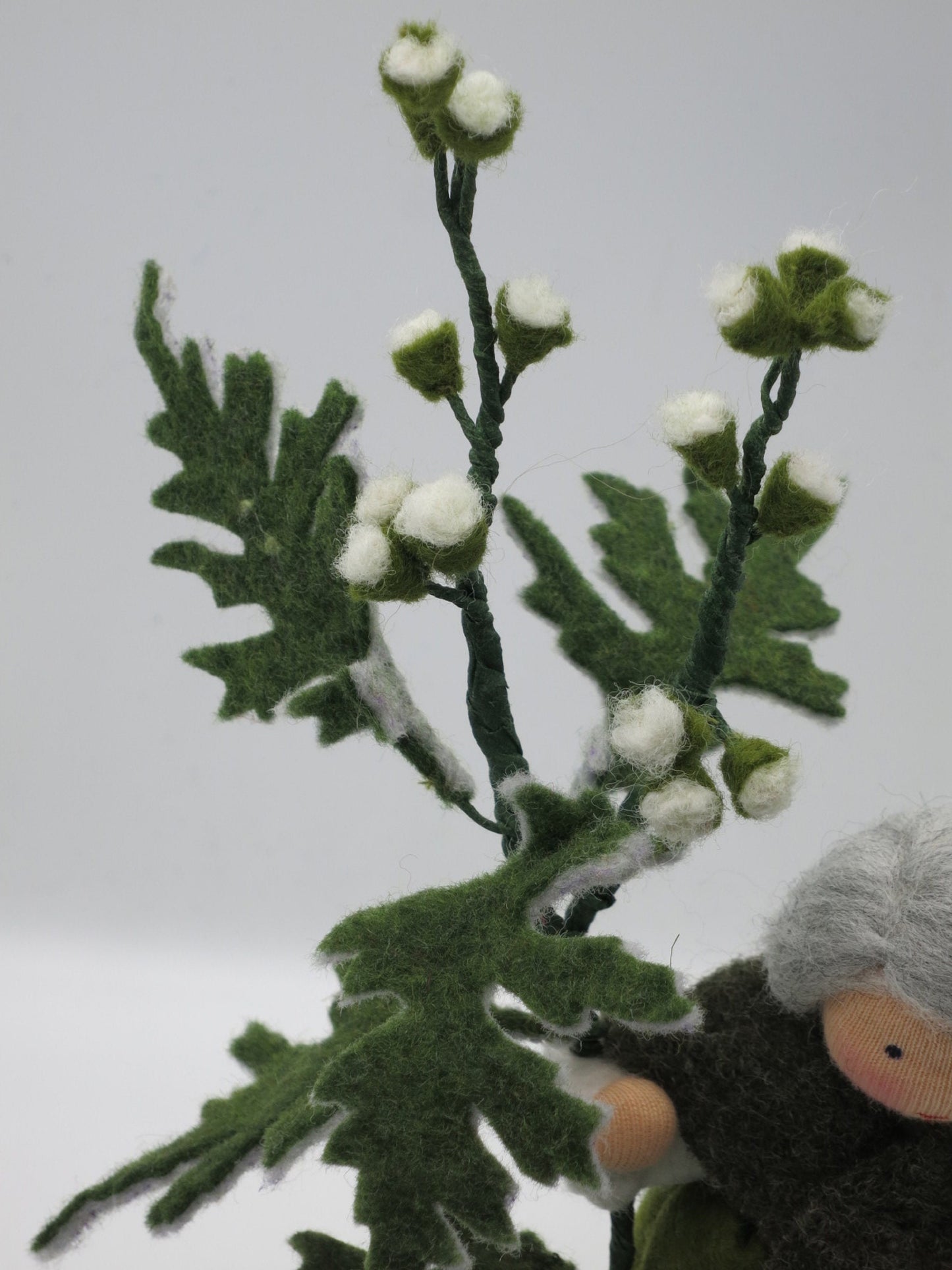 Detailaufnahme des Beifußzweigs aus Filz mit weißen Knospen und gezackten grünen Blättern am Blumenkind Art. SO16.