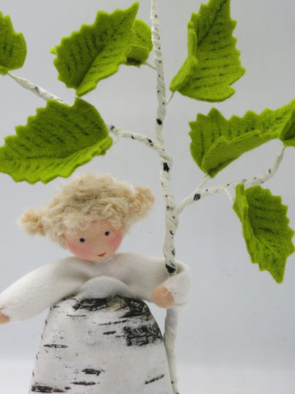 Handgefertigtes Birken-Mädchen als Waldorf-Baumkind Art. FR22 vor einem Birkenzweig mit frischen grünen Blättern für den Frühlings-Jahreszeitentisch.