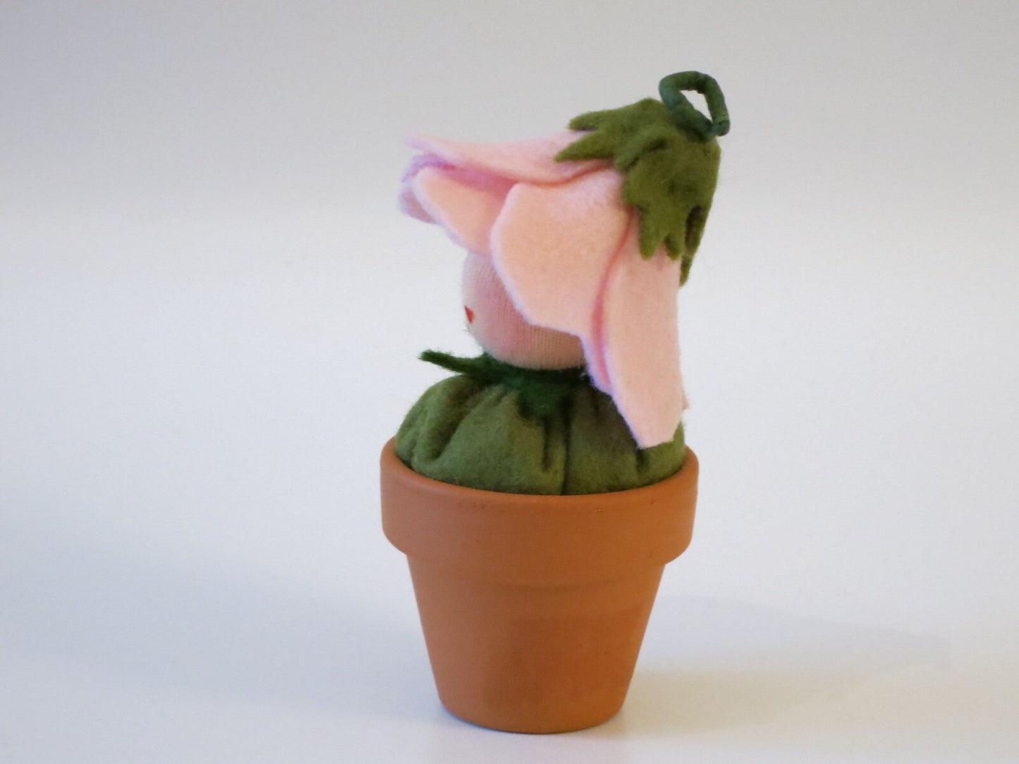 Rückansicht des Blümchen-im-Topf-Blumenkindes mit rosa Filzblütenblättern