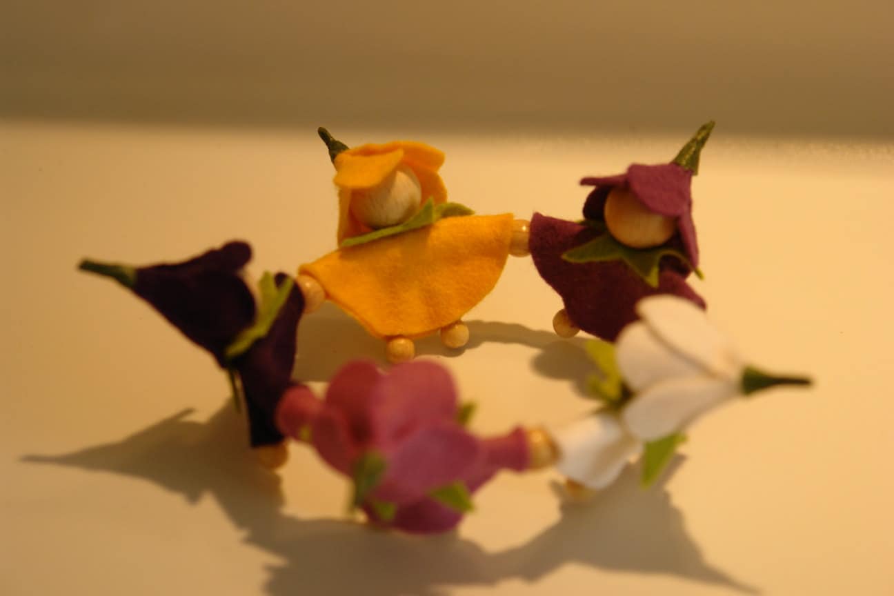 Handgefertigtes Blumenkränzchen mit fünf bunten Blumenkindern aus Filz für den Frühlings-Jahreszeitentisch.