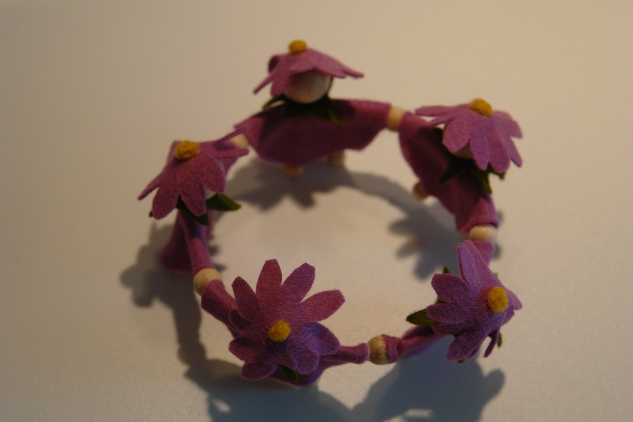 Handgefertigtes Blumenkränzchen mit violetten Filzblüten und kleinen Blumenkindern für den Frühlings-Jahreszeitentisch.