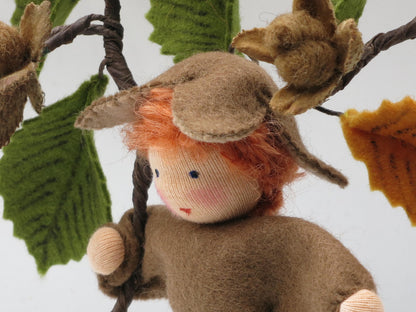 Halbporträt des Bucheckern-Jungen am Buchenzweig mit braunen Fruchthüllen und grünen Filzblättern.