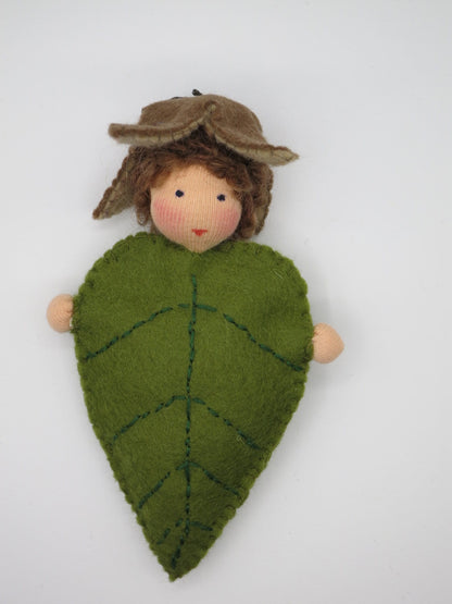 Handgefertigtes Buchenblätter-Kind mit braunen Haaren, grünem Filzblatt und Bucheckern-Hut als Herbstfigur