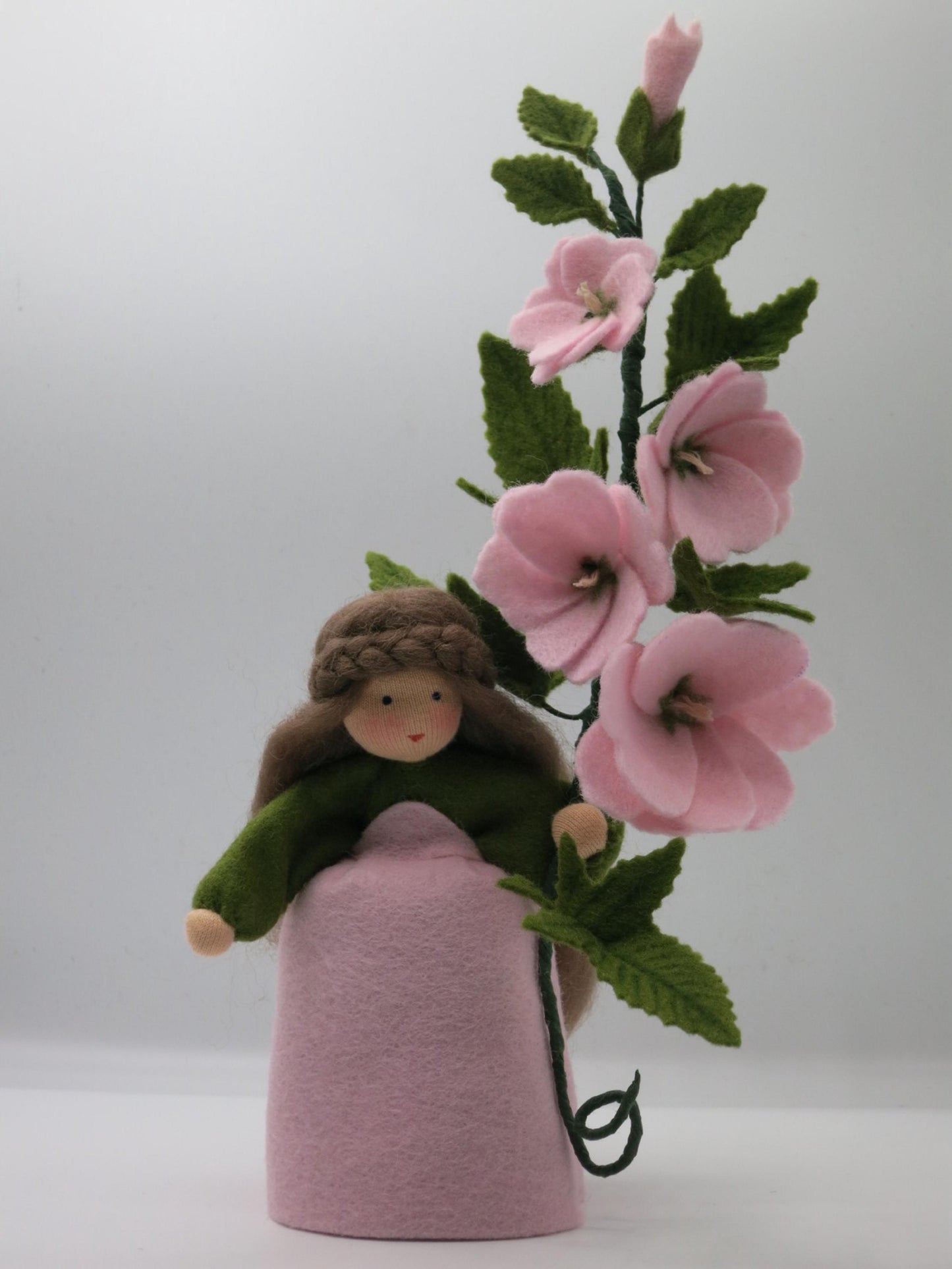 Buschmalve-Blumenkind mit rosa Blütenzweig und grünem Filz, handgefertigt für Waldorf-Jahreszeitentisch und Festtafel