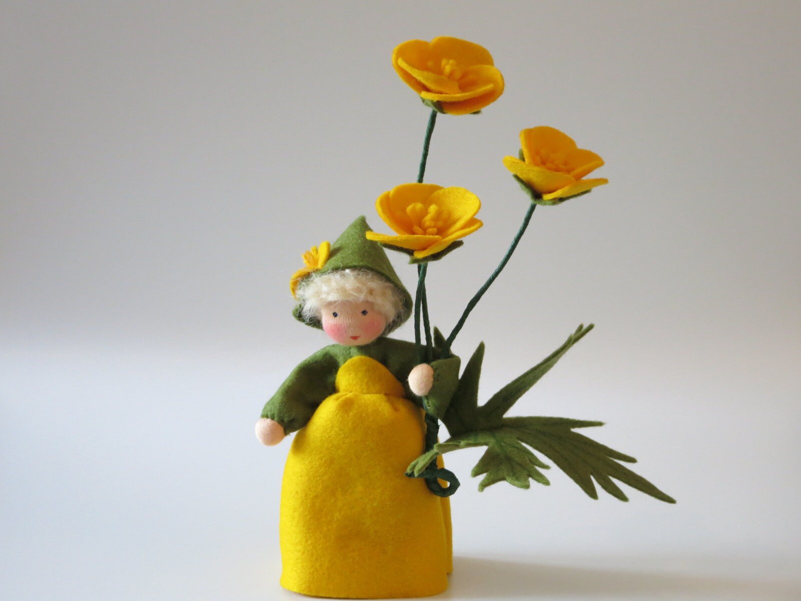 Butterblumen-Blumenkind mit gelben Blüten und grünen Blättern als handgefertigte Sommerfigur für den Jahreszeitentisch