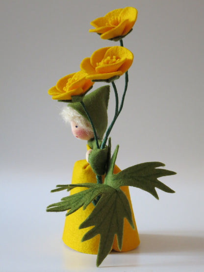 Seitliche Ansicht des Butterblumen-Blumenkinds mit drei gelben Filzblüten und großen grünen Butterblumenblättern