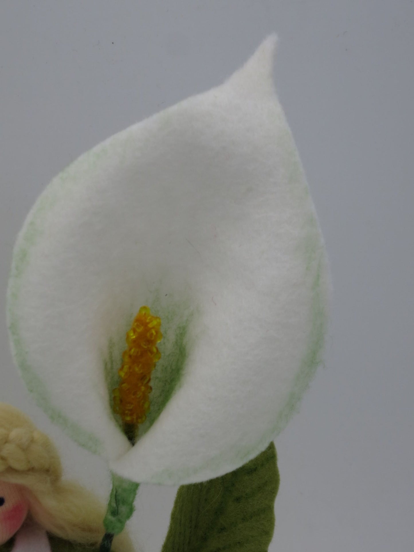 Nahaufnahme der charakteristischen weißen Calla-Blüte aus Filz mit gelbem Kolben und sanfter grüner Schattierung
