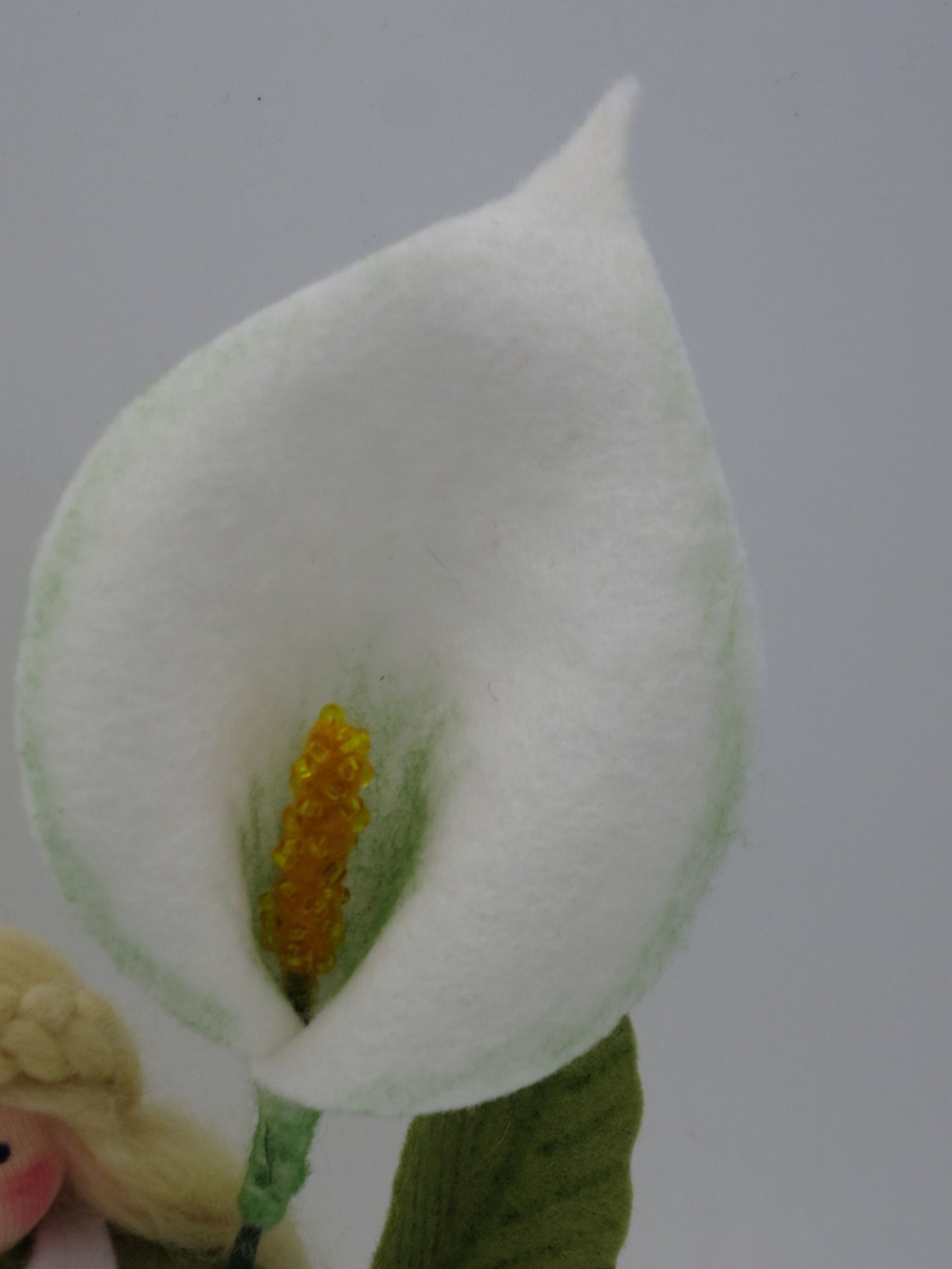 Nahaufnahme der charakteristischen weißen Calla-Blüte aus Filz mit gelbem Kolben und sanfter grüner Schattierung