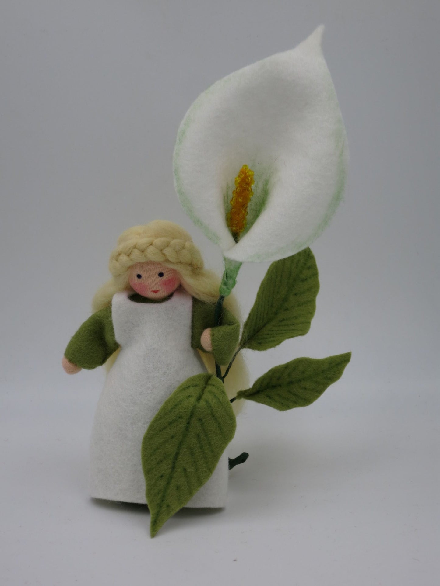 Calla-Blumenkind mit weißer Filzblüte und grünen Blättern, handgefertigt für den Waldorf-Jahreszeitentisch