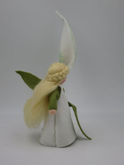 Calla-Blumenkind im Profil mit weißem Filzkleid, grünen Ärmeln, langem Blondhaar und hoher Blütenhaube