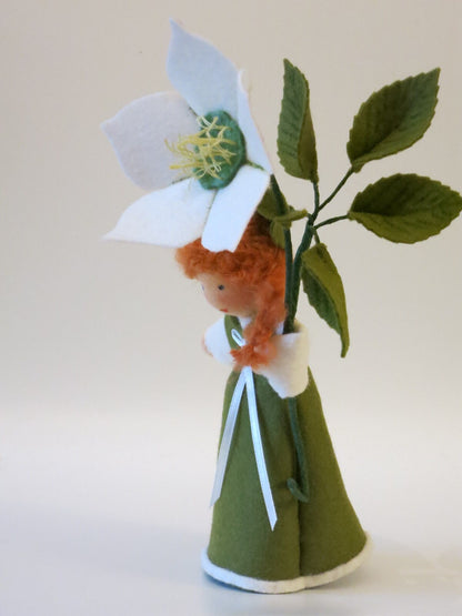 Seitliche Ansicht des Christrosen-Mädchens mit weißer Winterblüte, grünen Filzblättern und langem roten Haar