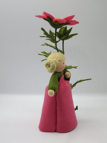 Cosmea-Blumenkind im Profil mit rosa Filzkleid, grünem Kragen und Schmuckkörbchen-Blüte über dem Kopf