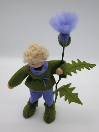 Handgefertigter Distel-Junge mit blondem Lockenhaar, grün-lila Filzkleidung und großer flauschiger Distelblüte