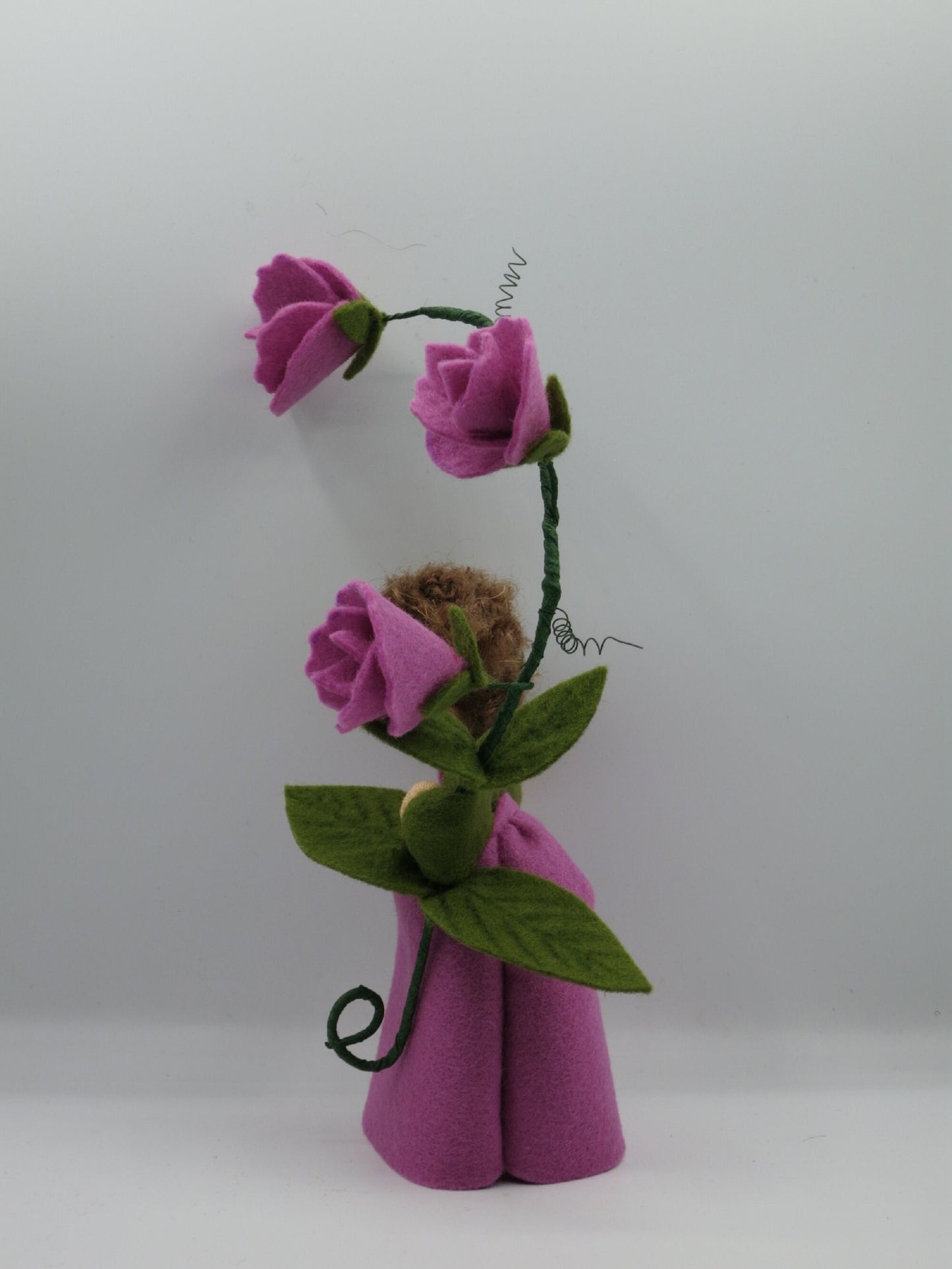 Seitenansicht des Duftwicken-Blumenkindes mit lila Filzkleid, grünen Ranken und drei Blüten