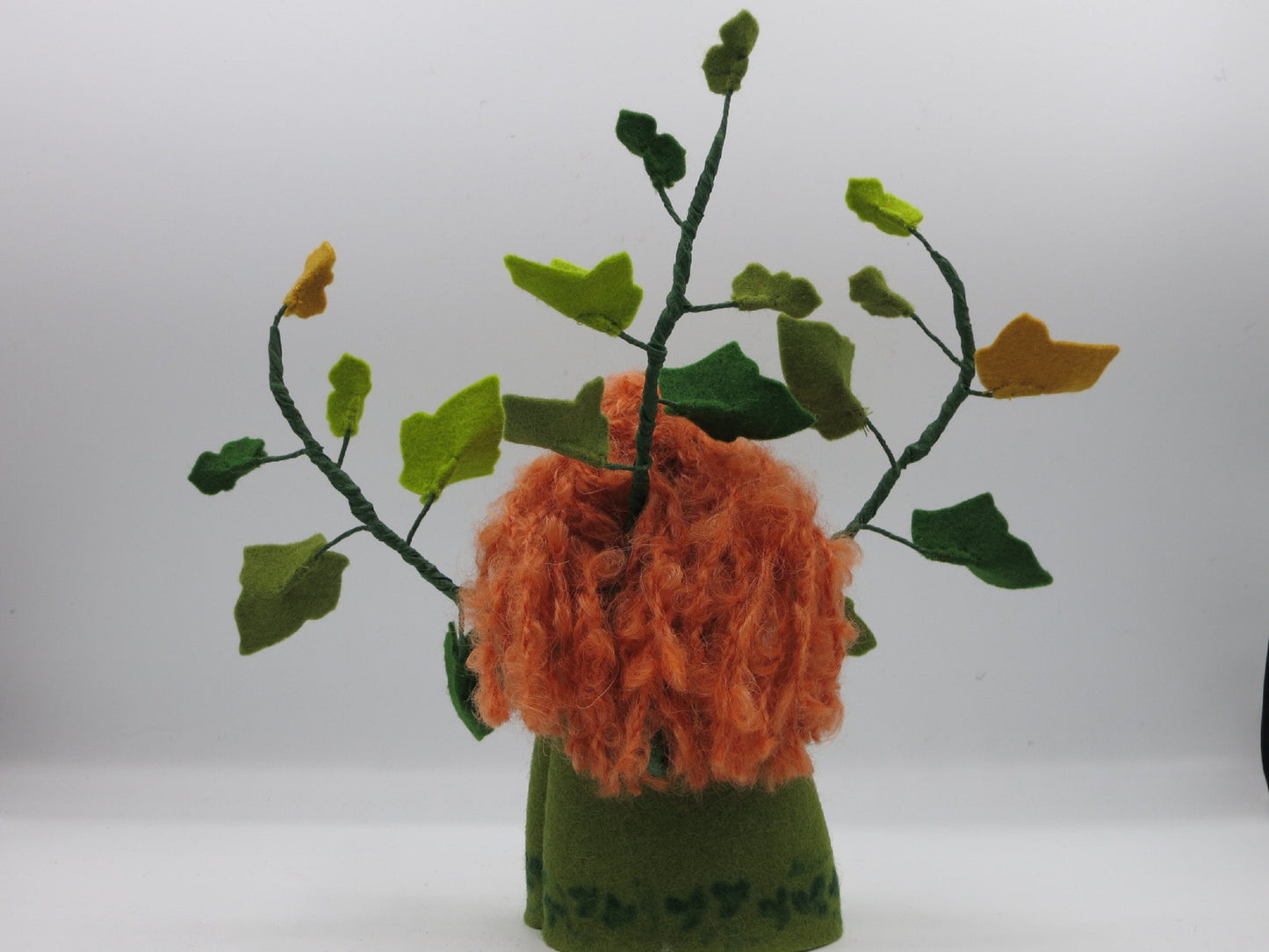 Rückansicht des handgefertigten Efeu-Blumenkindes mit rotem Lockenhaar und grünen Filzranken für die Herbstdekoration
