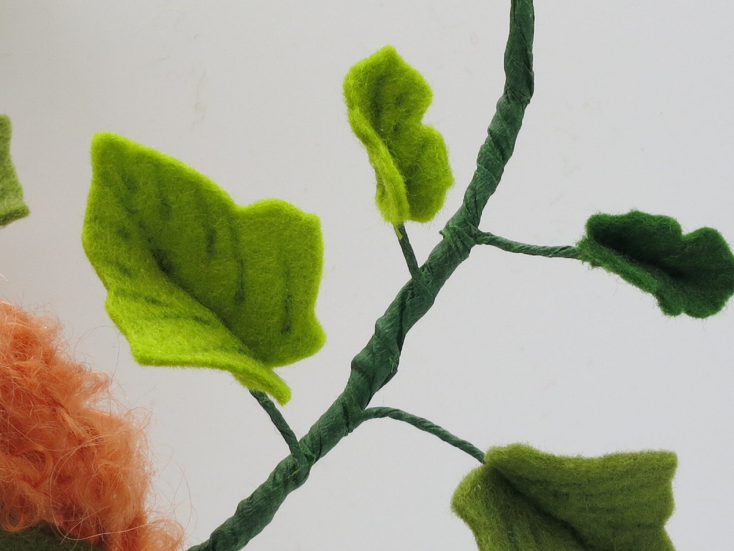 Detail der handgefertigten Efeuranke mit hell- und dunkelgrünen Filzblättern am Herbst-Blumenkind