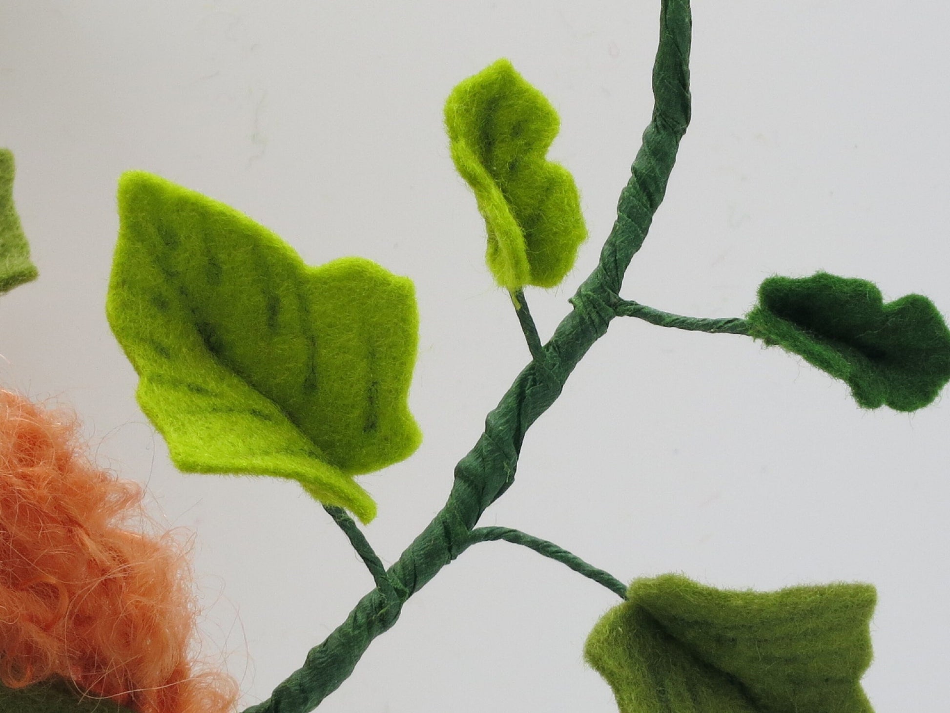 Detail der handgefertigten Efeuranke mit hell- und dunkelgrünen Filzblättern am Herbst-Blumenkind