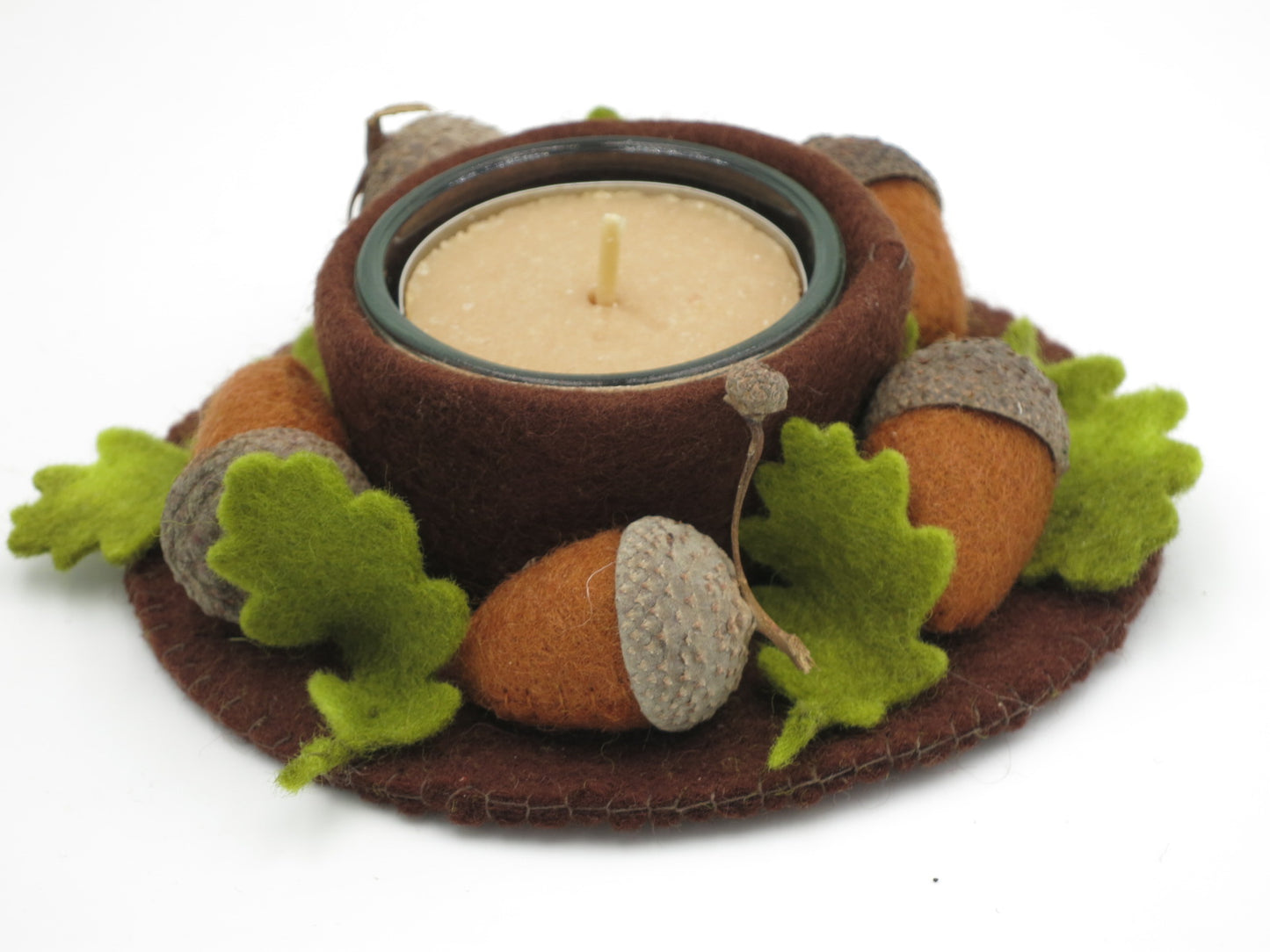 Filzkranz mit Teelicht, braunen Eicheln und grünen Eichenblättern als Herbstdekoration für den Jahreszeitentisch.