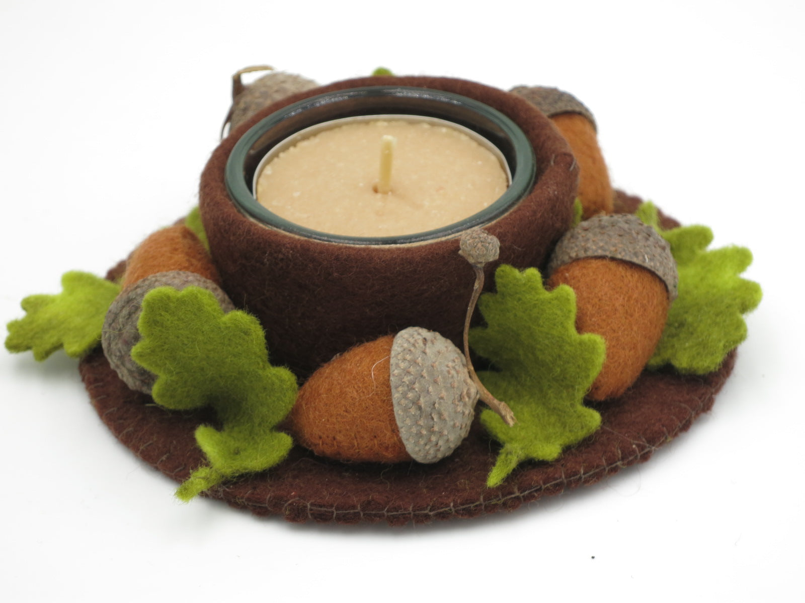 Filzkranz mit Teelicht, braunen Eicheln und grünen Eichenblättern als Herbstdekoration für den Jahreszeitentisch.