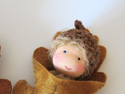 Porträt eines Eichelbabys als handgefertigte Filzpuppe in einer Blätterhülle für den Waldorf-Jahreszeitentisch.
