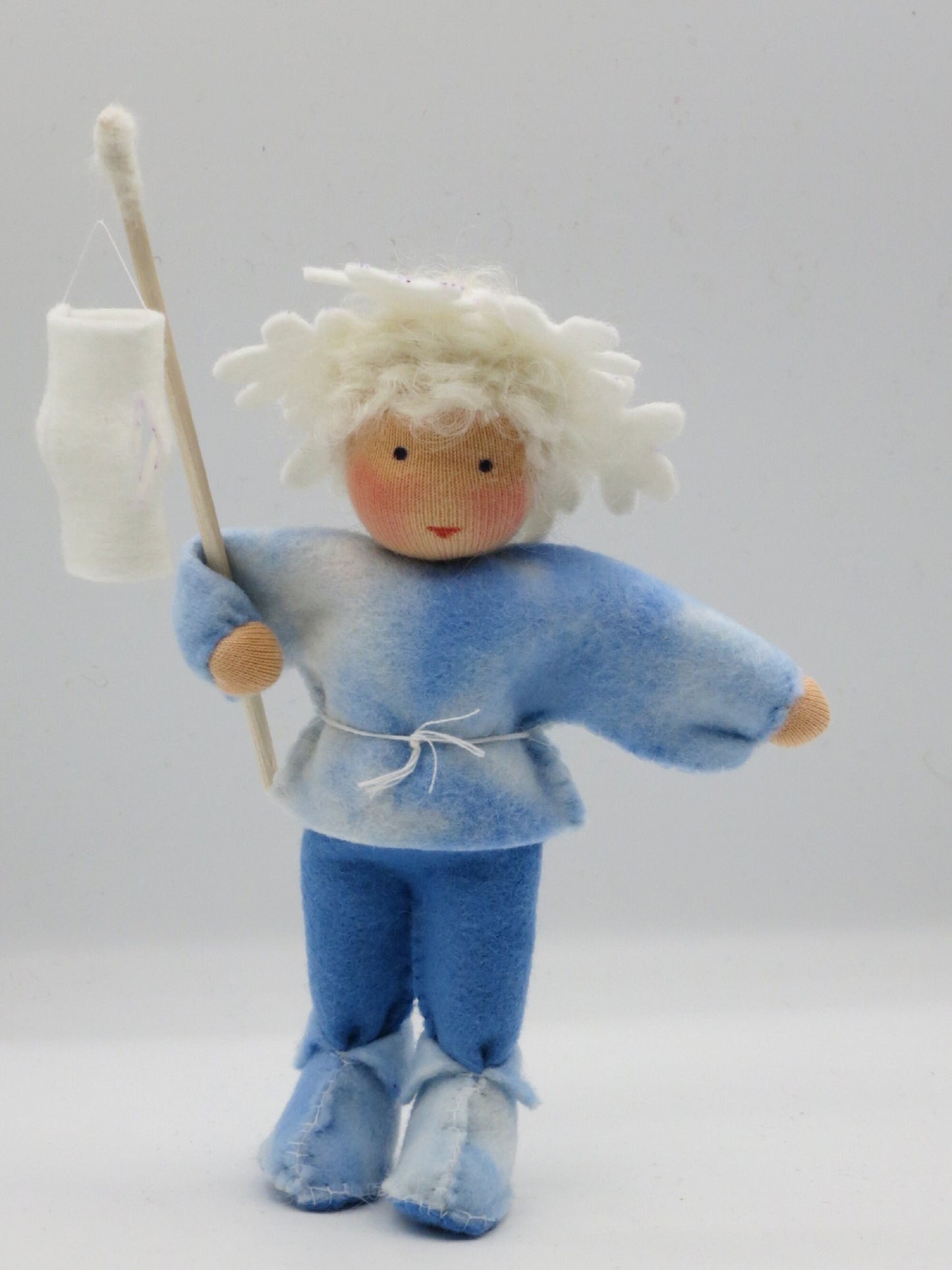 Handgefertigtes Eiskristall-Blumenkind aus Filz mit weißer Laterne für den winterlichen Waldorf-Jahreszeitentisch.