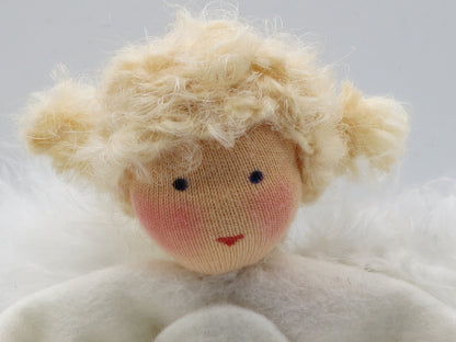 Detailaufnahme des blonden Engels aus Wollfilz mit weißen Flügeln für die Weihnachtsdekoration.