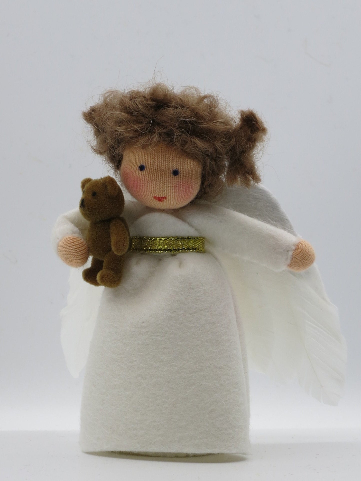 Handgefertigtes Engelchen aus Wollfilz mit weißen Flügeln und kleinem Teddy für den Waldorf-Jahreszeitentisch.