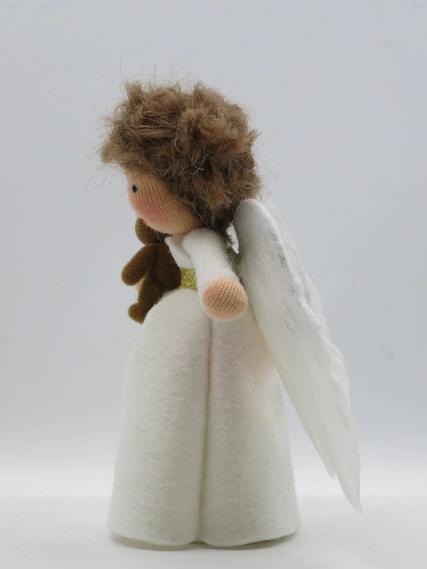 Seitenansicht eines Wollfilz-Engelchens mit Teddy, lockigem Haar und weißen Flügeln für Winter und Weihnachten.