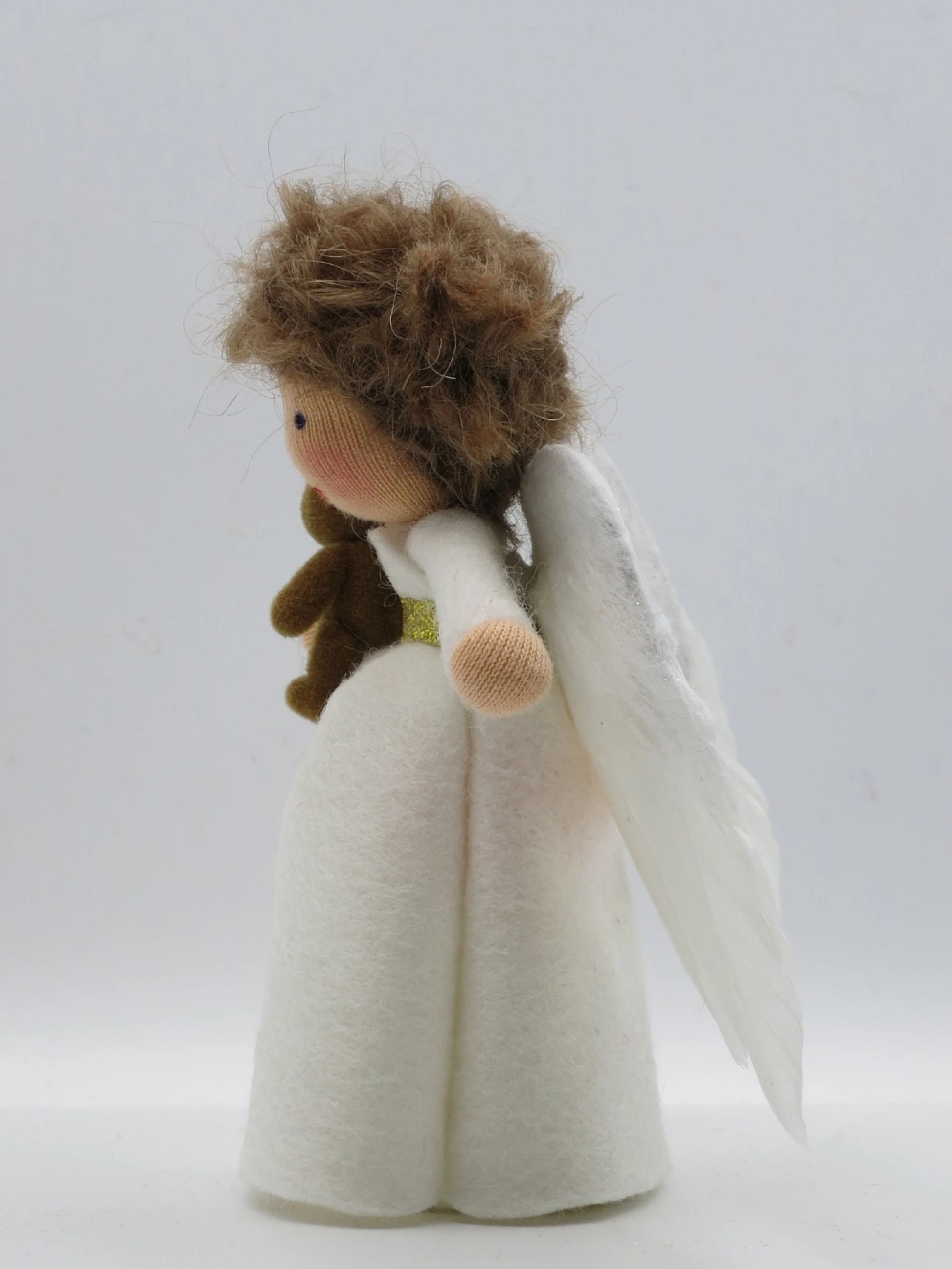 Seitenansicht eines Wollfilz-Engelchens mit Teddy, lockigem Haar und weißen Flügeln für Winter und Weihnachten.