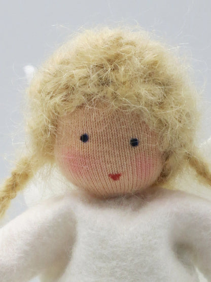 Detailansicht des handgefertigten Engelchens aus Wollfilz mit blondem Lockenhaar und weißem Kleid.