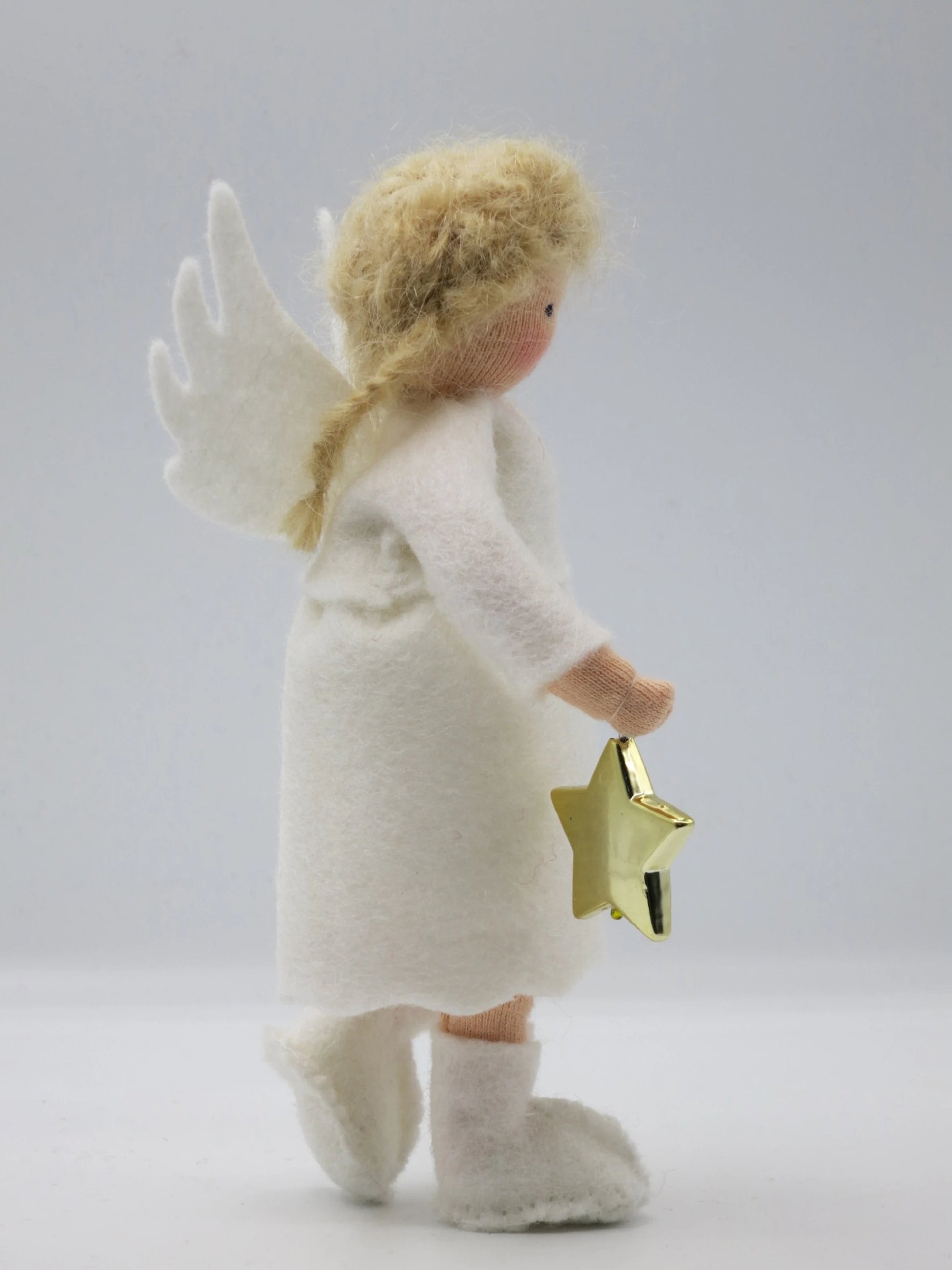 Seitliche Rückansicht des Wollfilz-Engelchens mit weißem Flügel, langem Zopf und goldenem Stern.