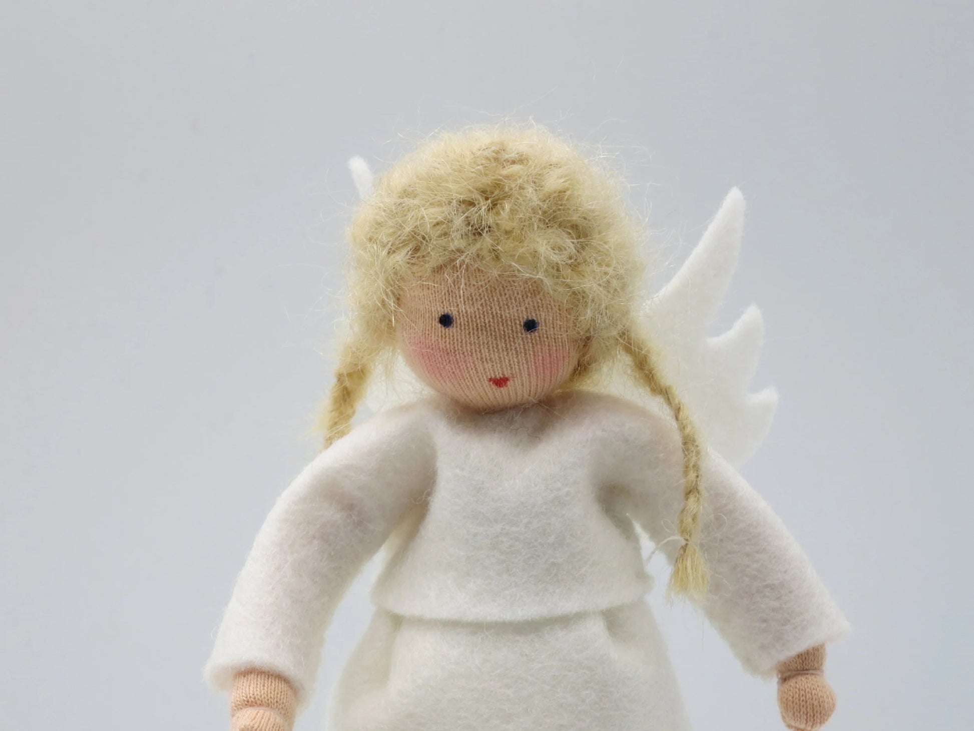 Porträt des handgefertigten Engelchens aus Wollfilz mit blondem Haar, weißem Kleid und kleinen Flügeln.