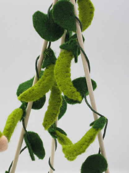 Porträt der Erbsenranke aus Wollfilz mit langen grünen Schoten als Detail der sommerlichen Gemüsegarten-Dekoration.